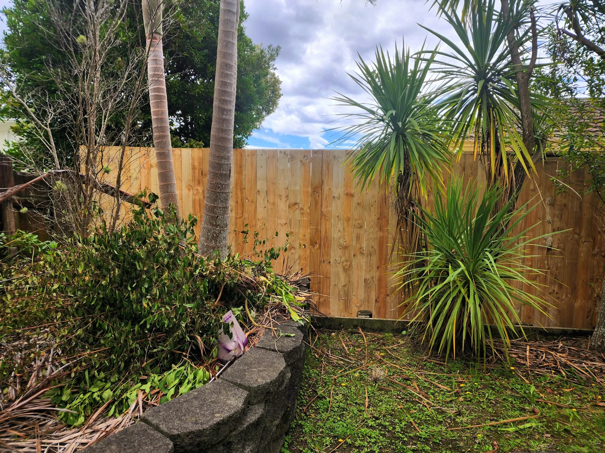 Modern timber and stone retaining wall creating tiered landscaping on a sloped property