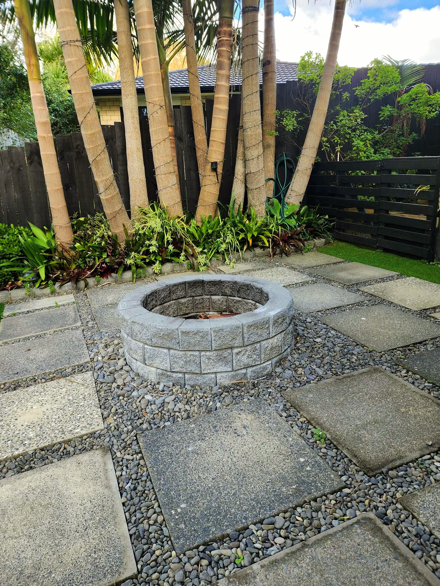 Elegant stone paved pathway winding through a manicured Auckland backyard garden