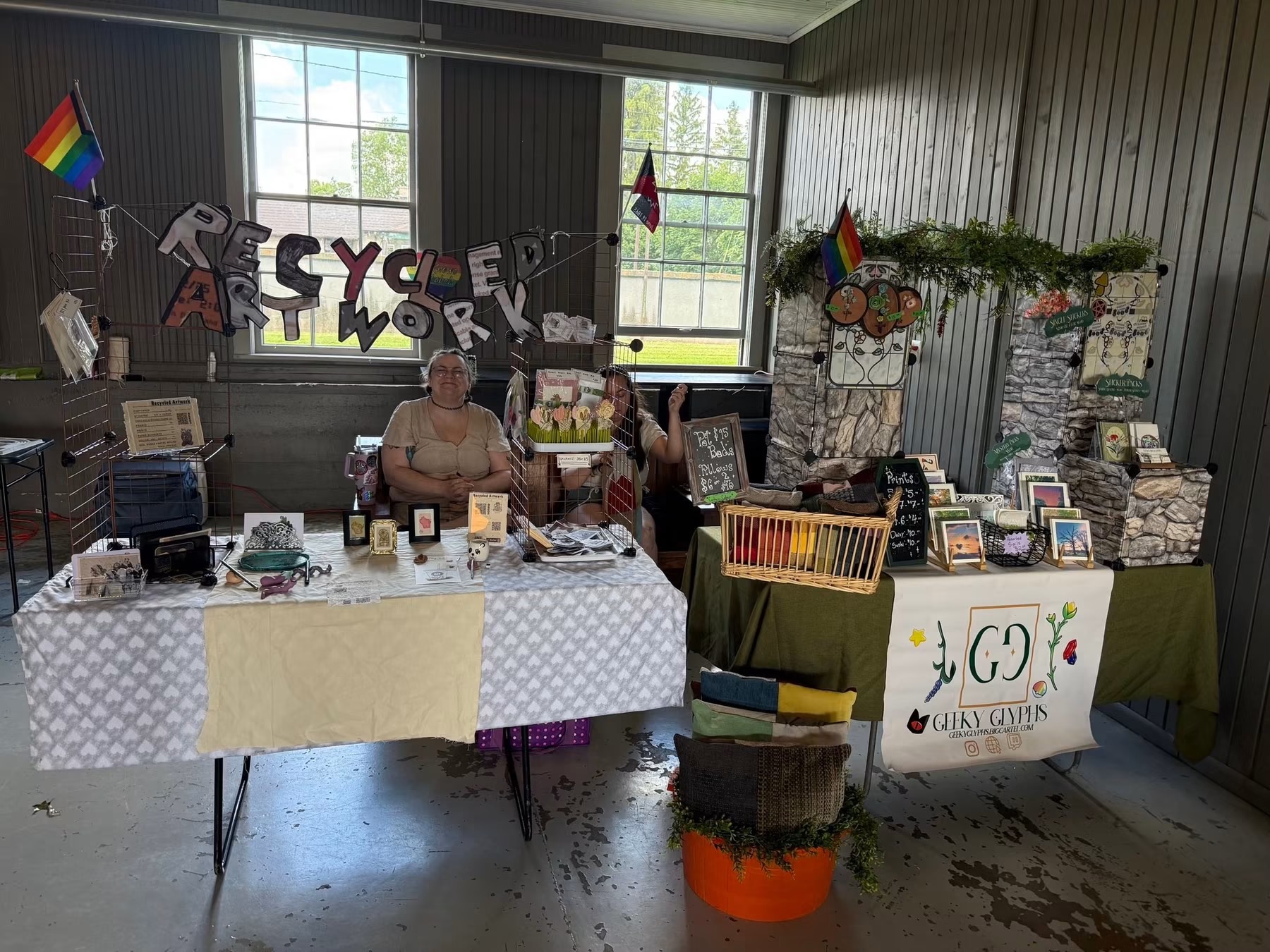 A colorful artisan vendor booth filled with handmade crafts and jewelry at a bustling community street fair