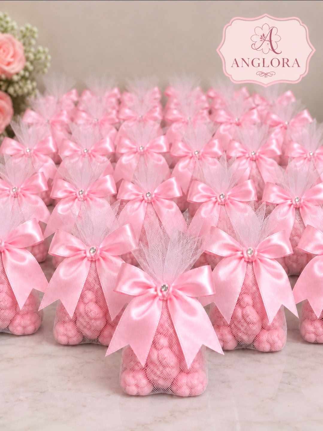 Soft pastel pink and blue baby shower candles decorated with tiny knitted booties and pearl accents