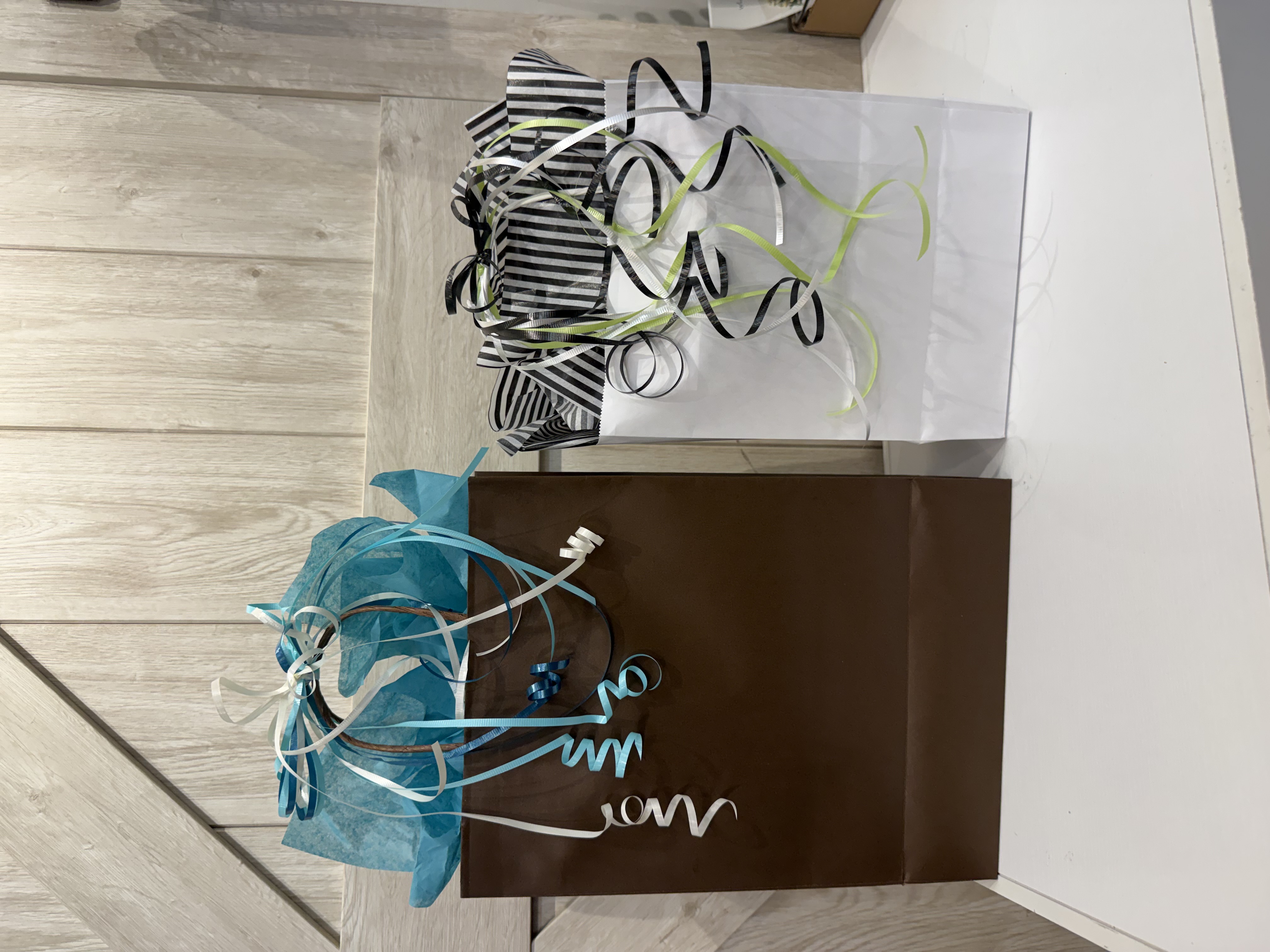 A beautifully wrapped gift box from The Gift Box, adorned with elegant paper, a silk ribbon, and a custom floral accent