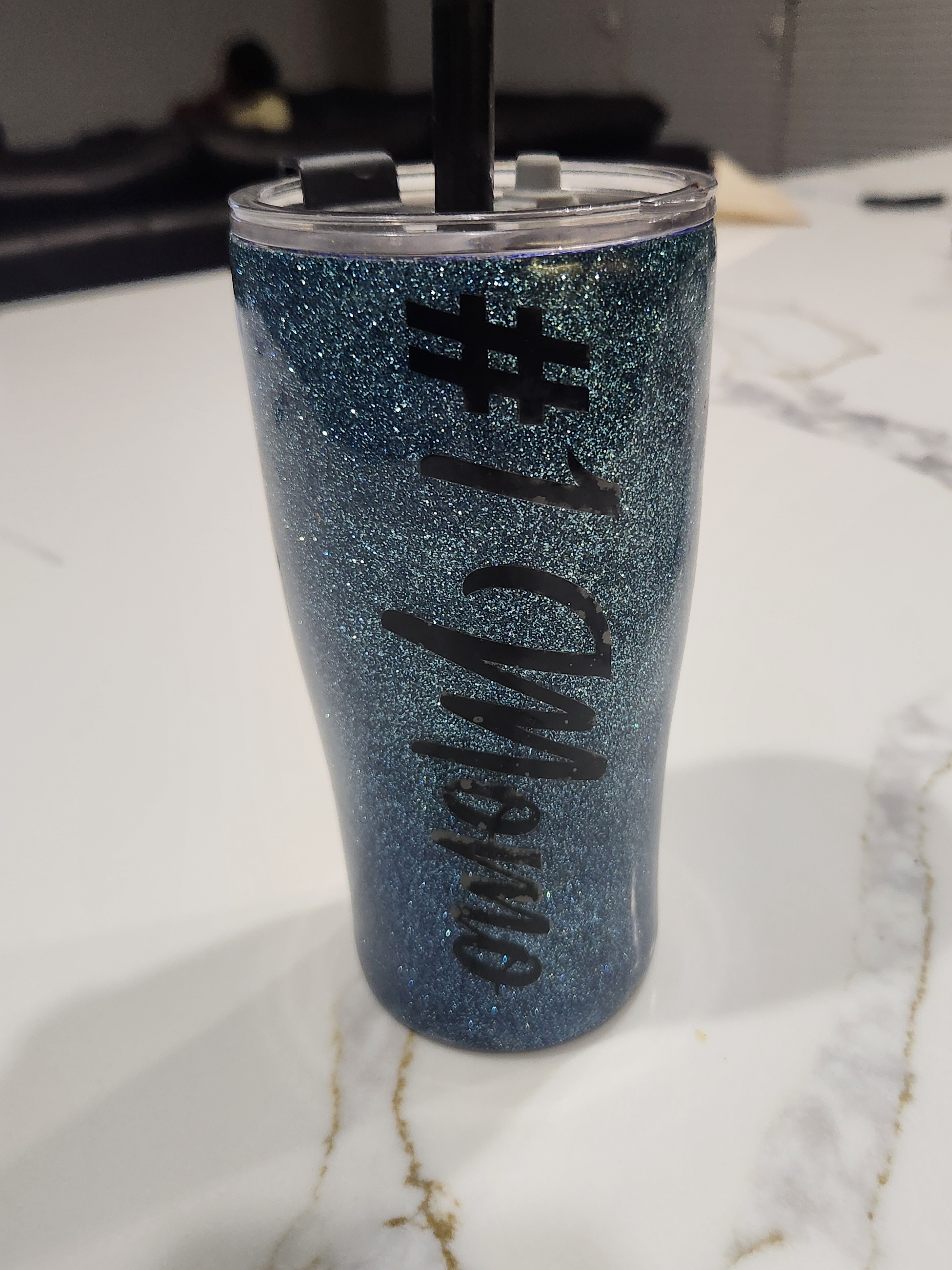 An elegant custom tumbler featuring rose gold glitter with a delicate floral decal design.