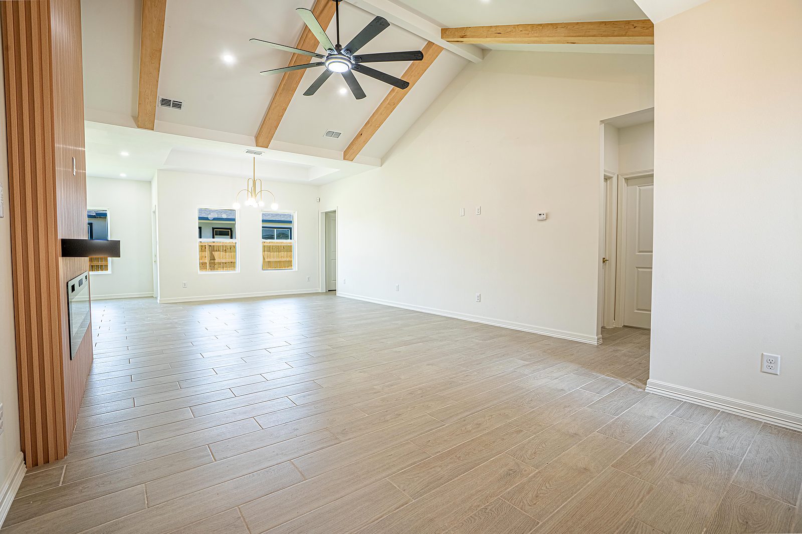 Great room with exposed wood beam ceiling and wood panel accent