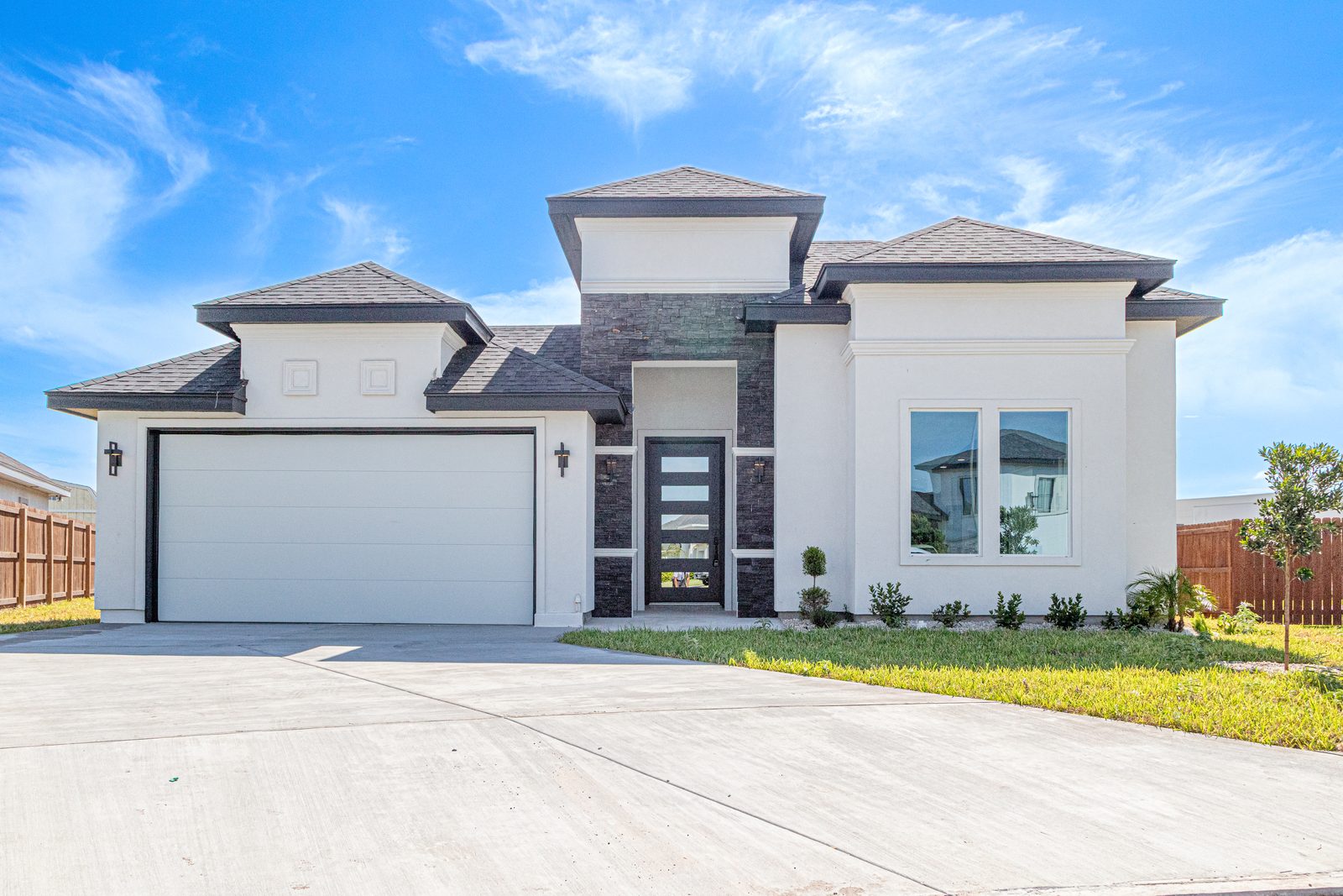 Modern white stucco and stone home with two-car garage