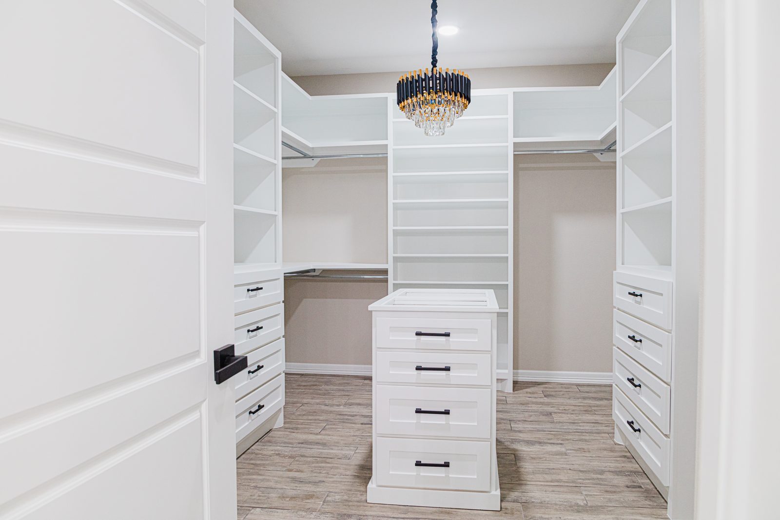 Walk-in closet with crystal chandelier and center island
