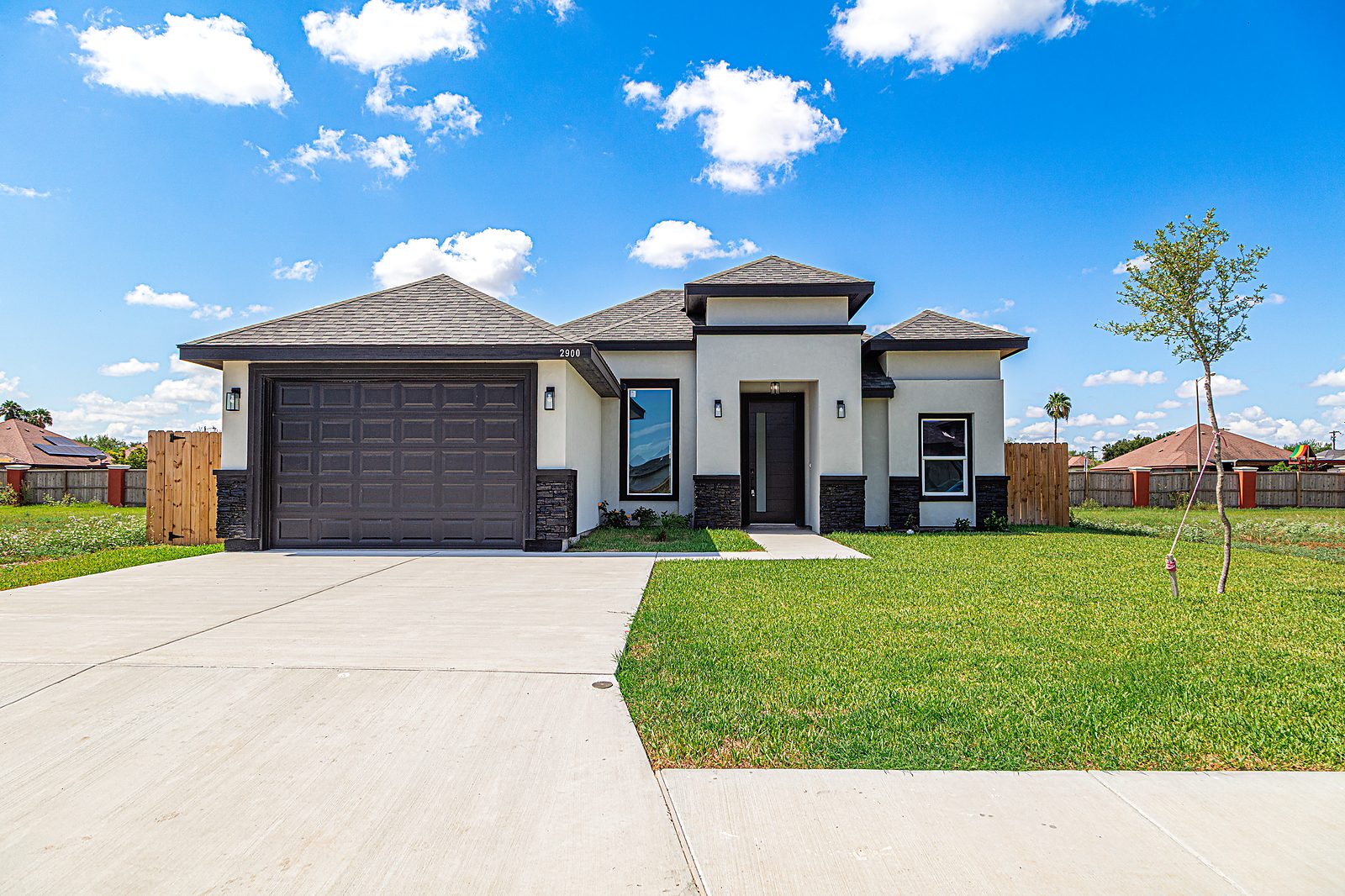 Home front with stucco, stone, and black modern door