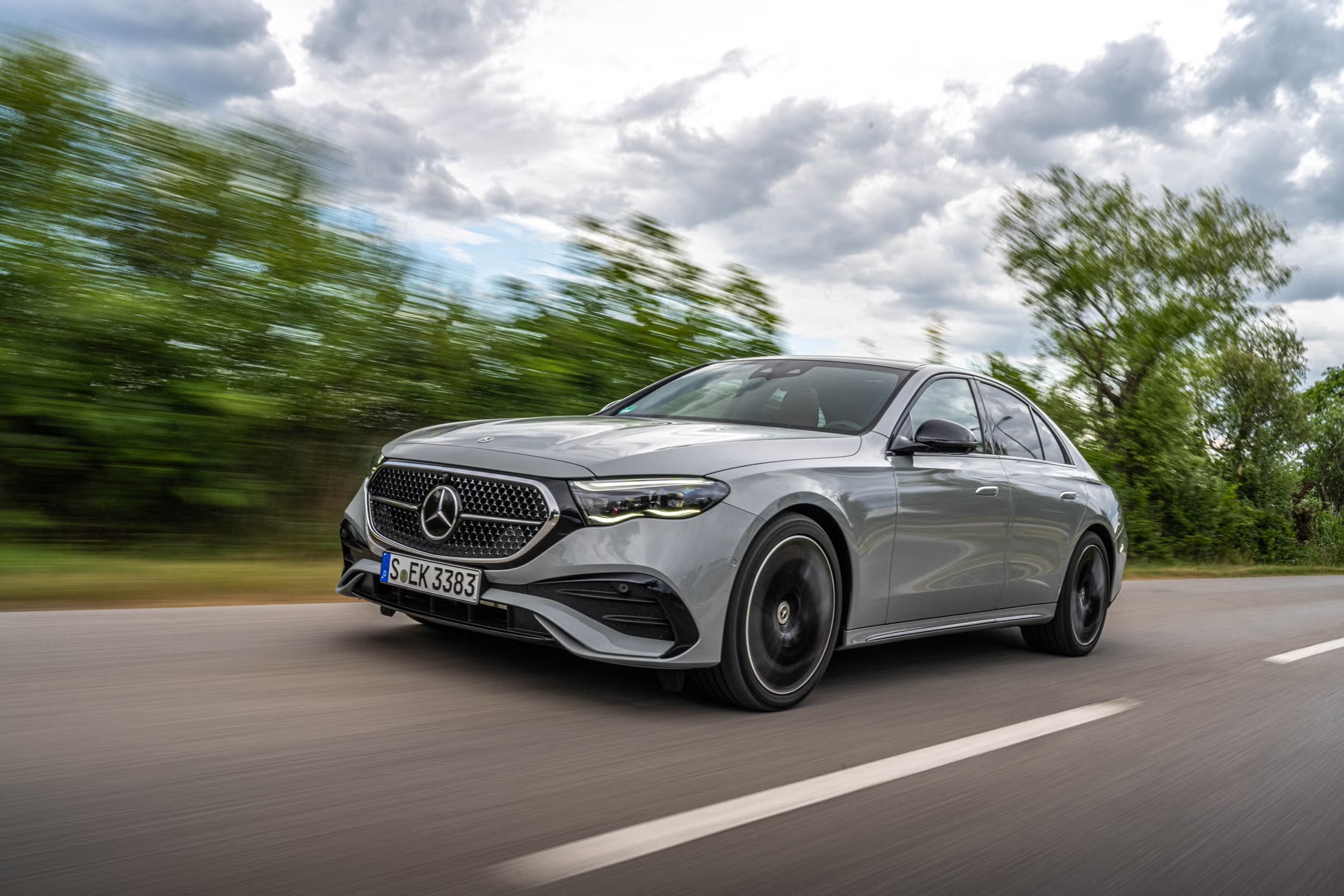 A sleek black luxury sedan parked on a modern city street at dusk with soft ambient lighting
