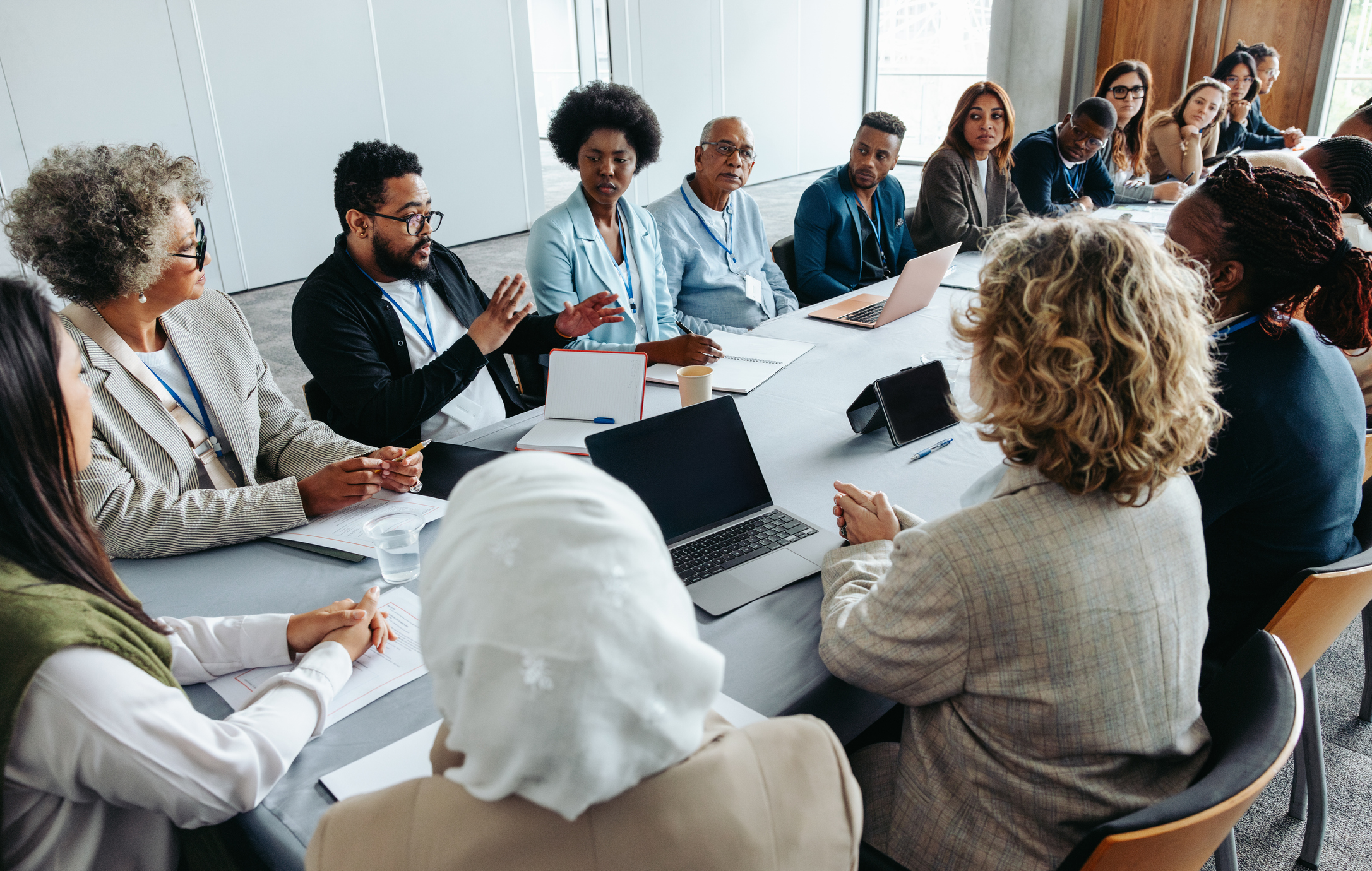 Diverse multiethnic marketing team including Black, Asian, Hispanic, and White professionals collaborating together in a modern, sunlit boardroom