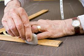 Master tailor precisely measuring a bespoke suit with chalk and measuring tape