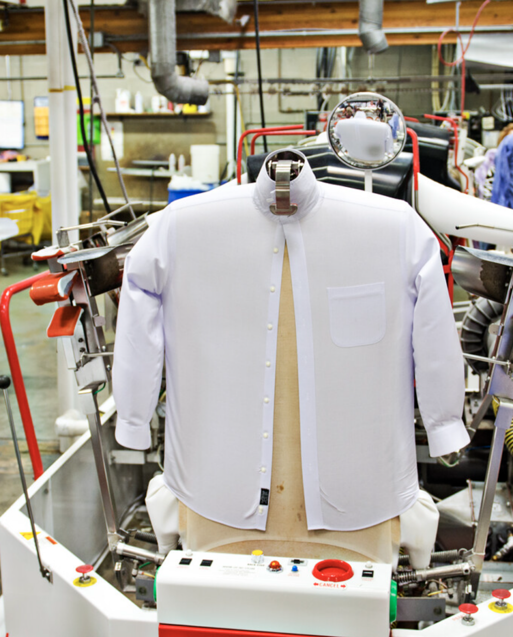 Pristine white pressed dress shirts on wooden hangers