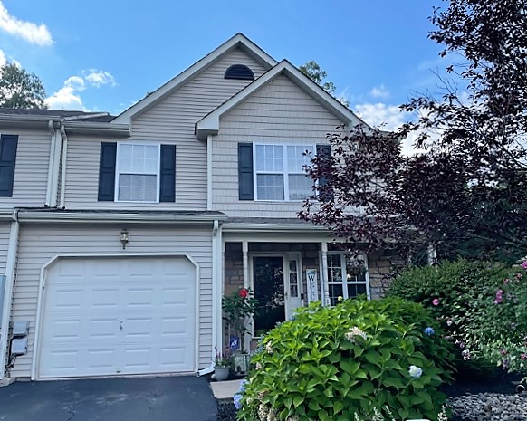 Luxury brick and stone townhome exterior overlooking the Sand Springs golf course at golden hour in Drums, Pennsylvania
