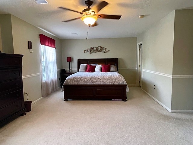 Serene primary bedroom suite with large windows and refined linens in luxury townhome