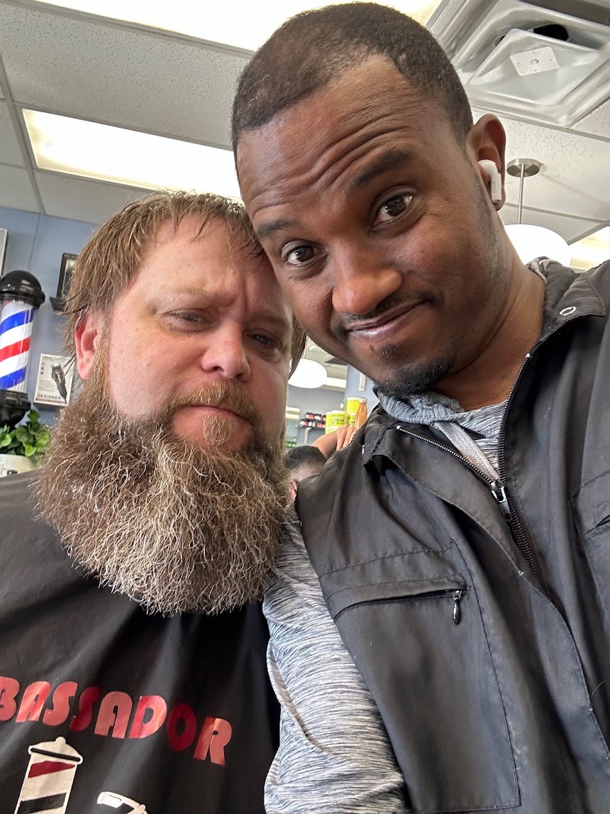 Master barber giving a precision fade haircut inside Ambassador Barber Shop in Calgary with vintage leather chairs