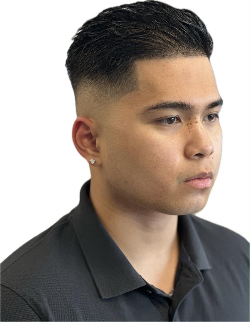 Master barber giving a precision fade haircut to a client in vintage Ambassador Barber Shop interior in Calgary