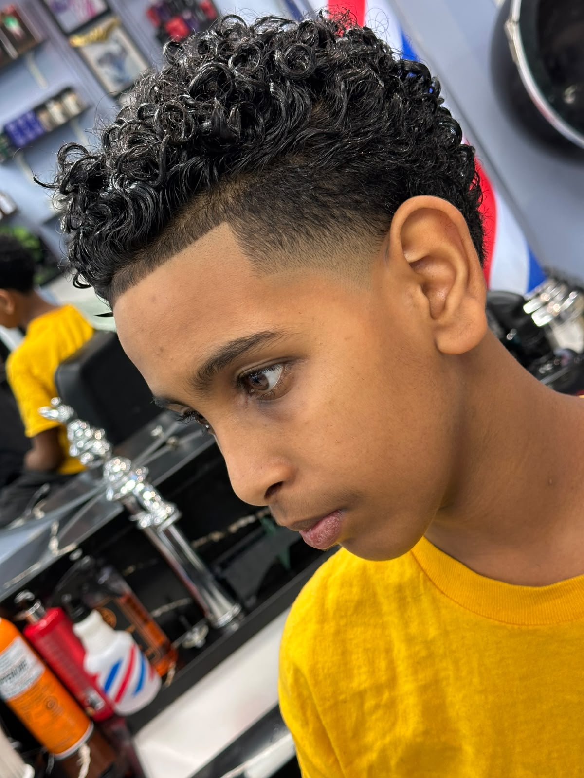 Textured crop haircut with messy fringe on young male client at Ambassador Barber Shop Calgary