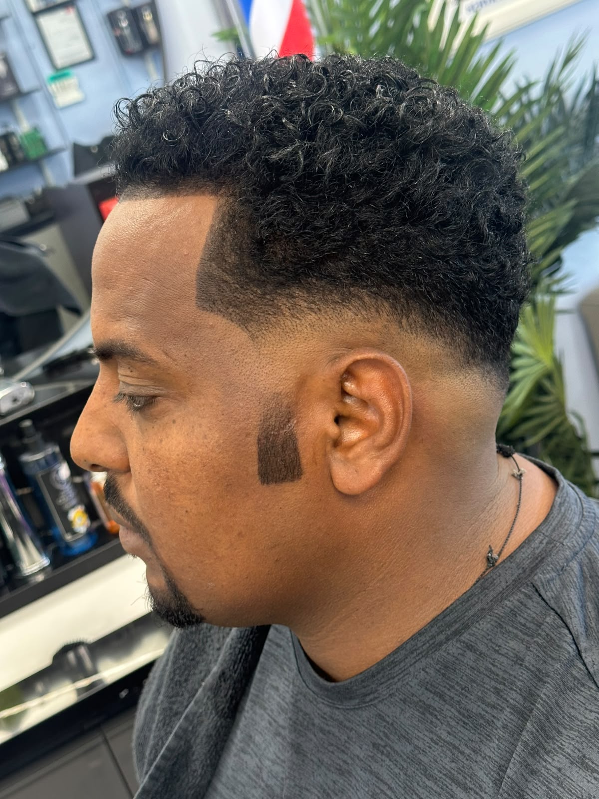 Glossy slick back hairstyle with pomade finish at Ambassador Barber Shop Calgary