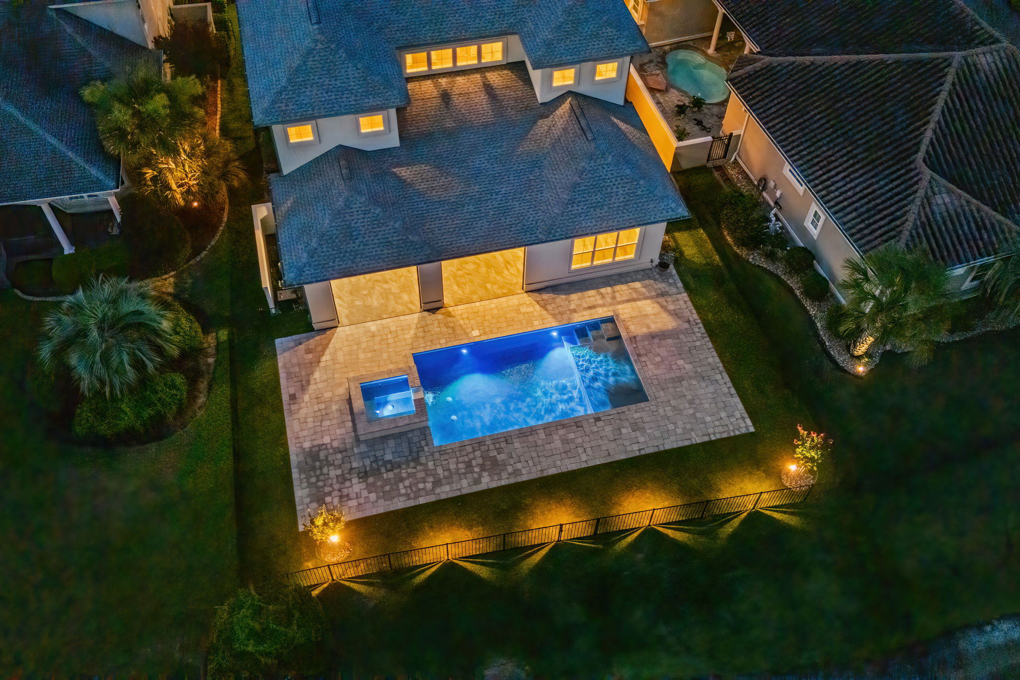 Modern swimming pool and backyard oasis with sophisticated ambient lighting for entertaining