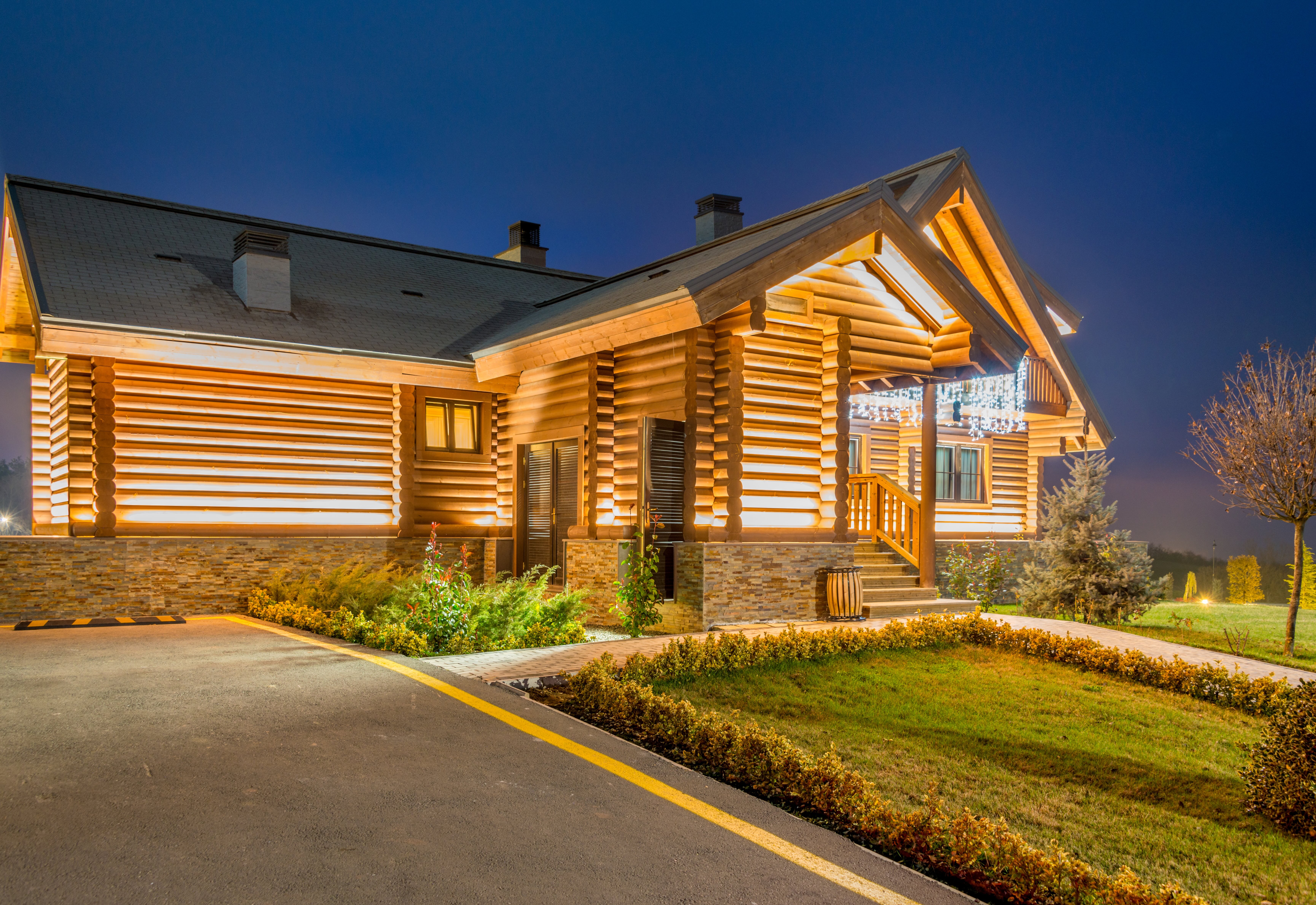 Elegant outdoor landscape lighting illuminating a coastal home at dusk with warm ambient glow