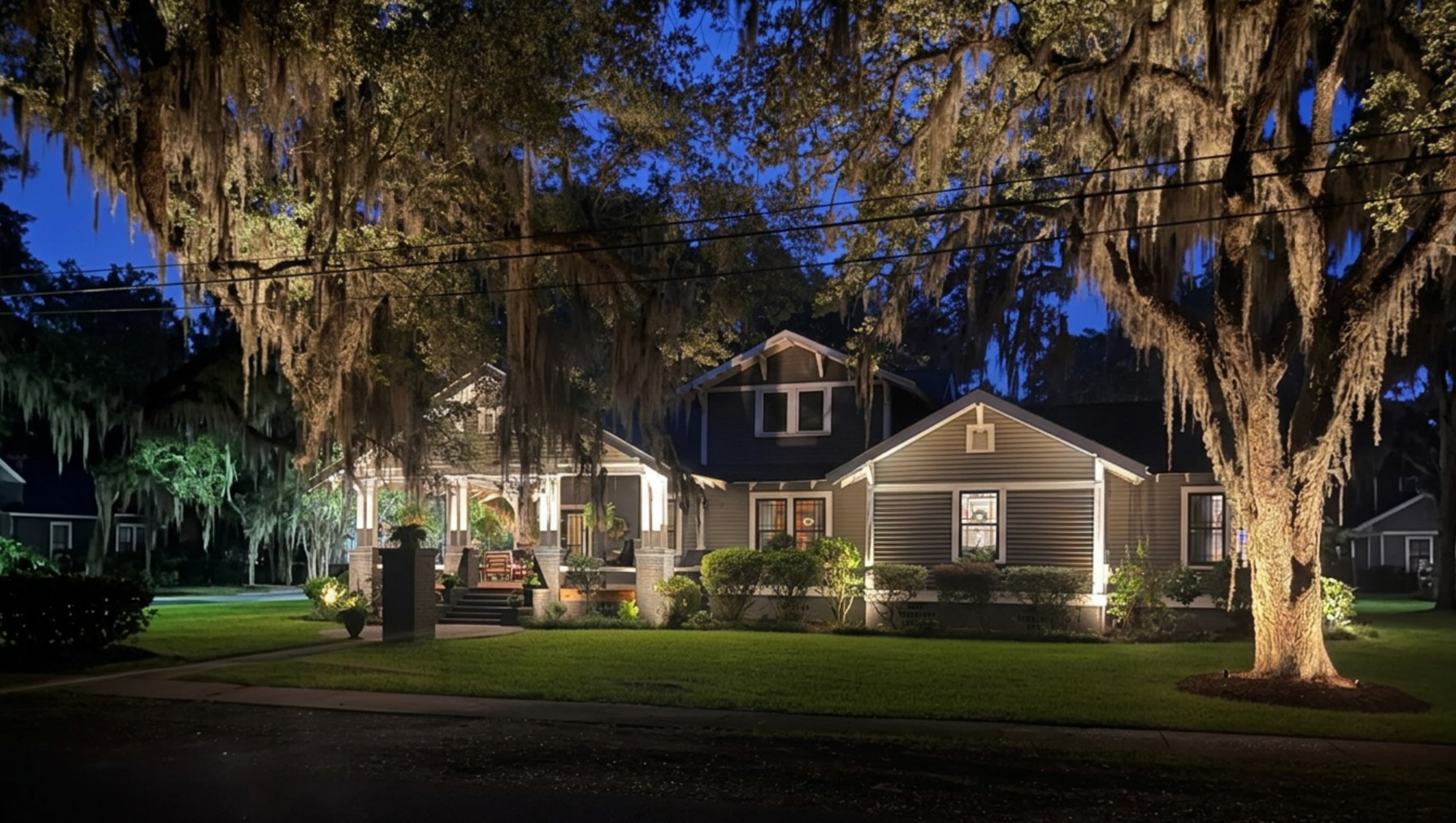 Charming coastal cottage porch with warm sconce lighting and hanging lanterns