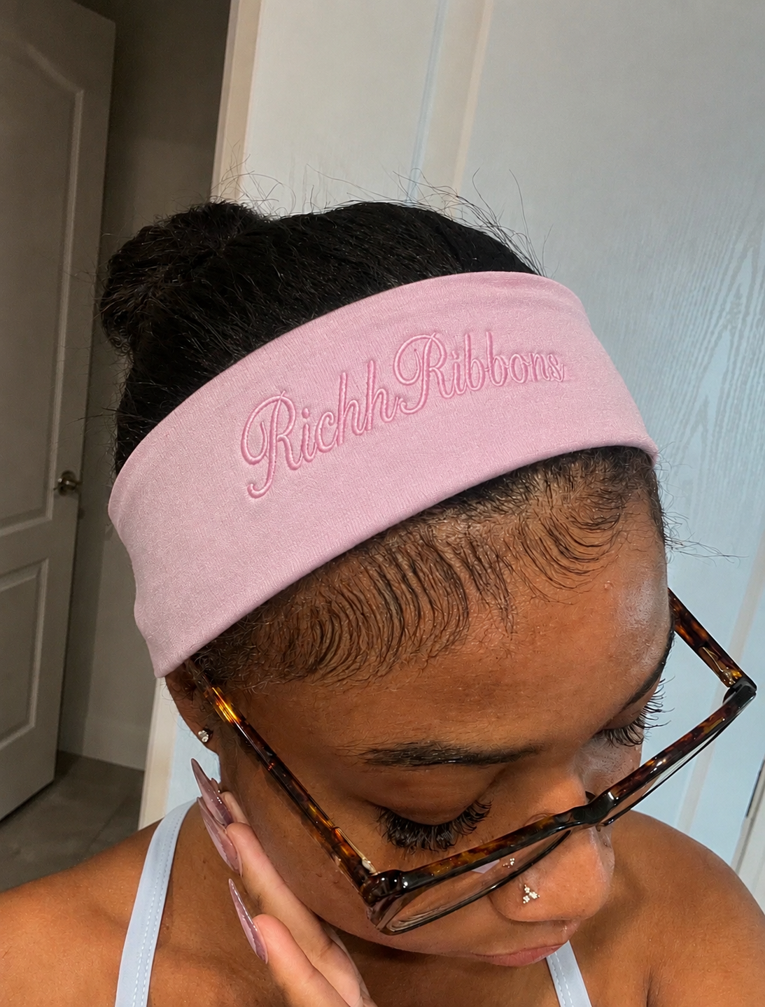 Black girl wearing a plain pastel pink headband with no bow, soft feminine style