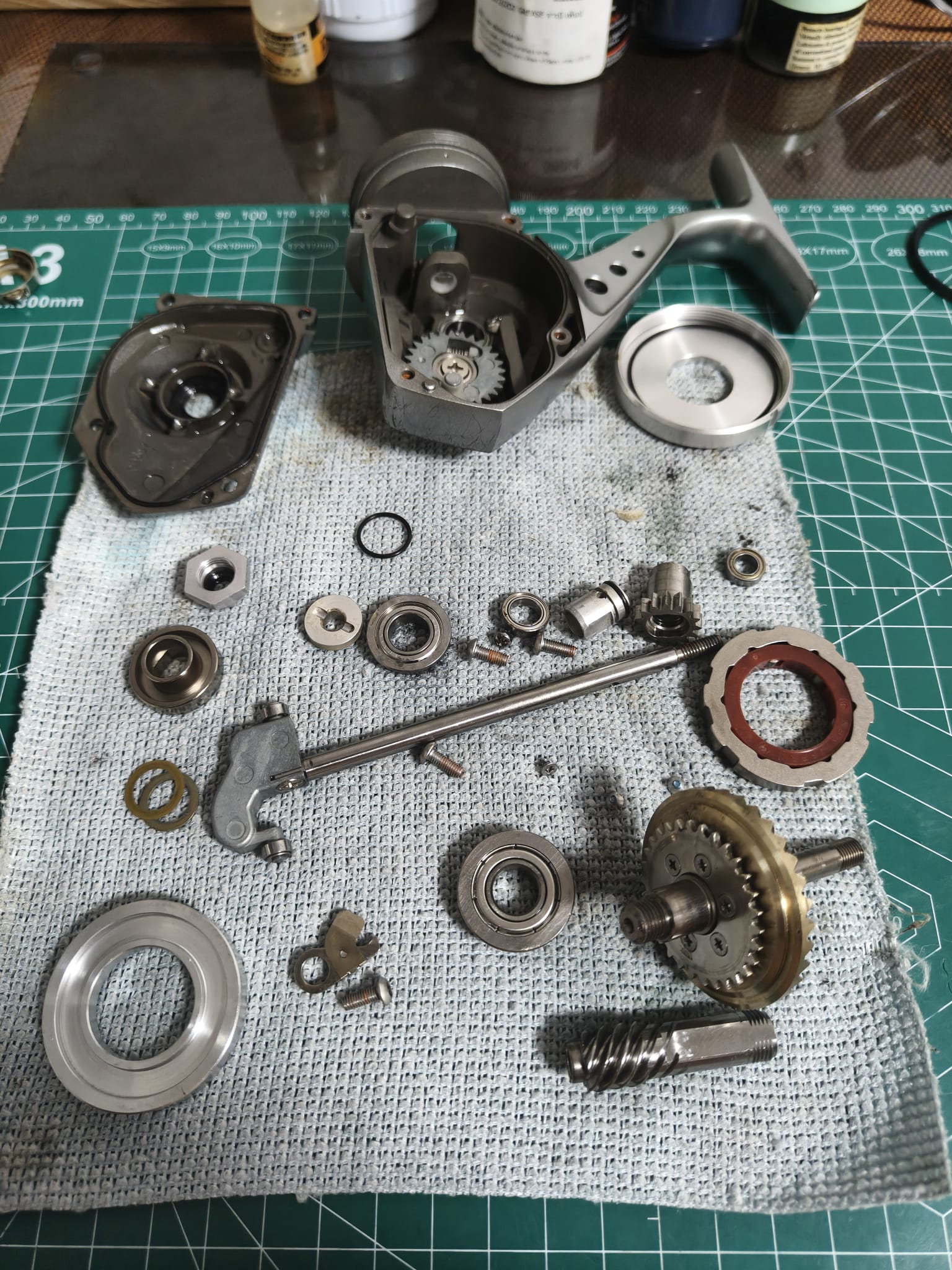 Replacement gear parts and components laid out for Miya Epoch electric reel rebuild and repair