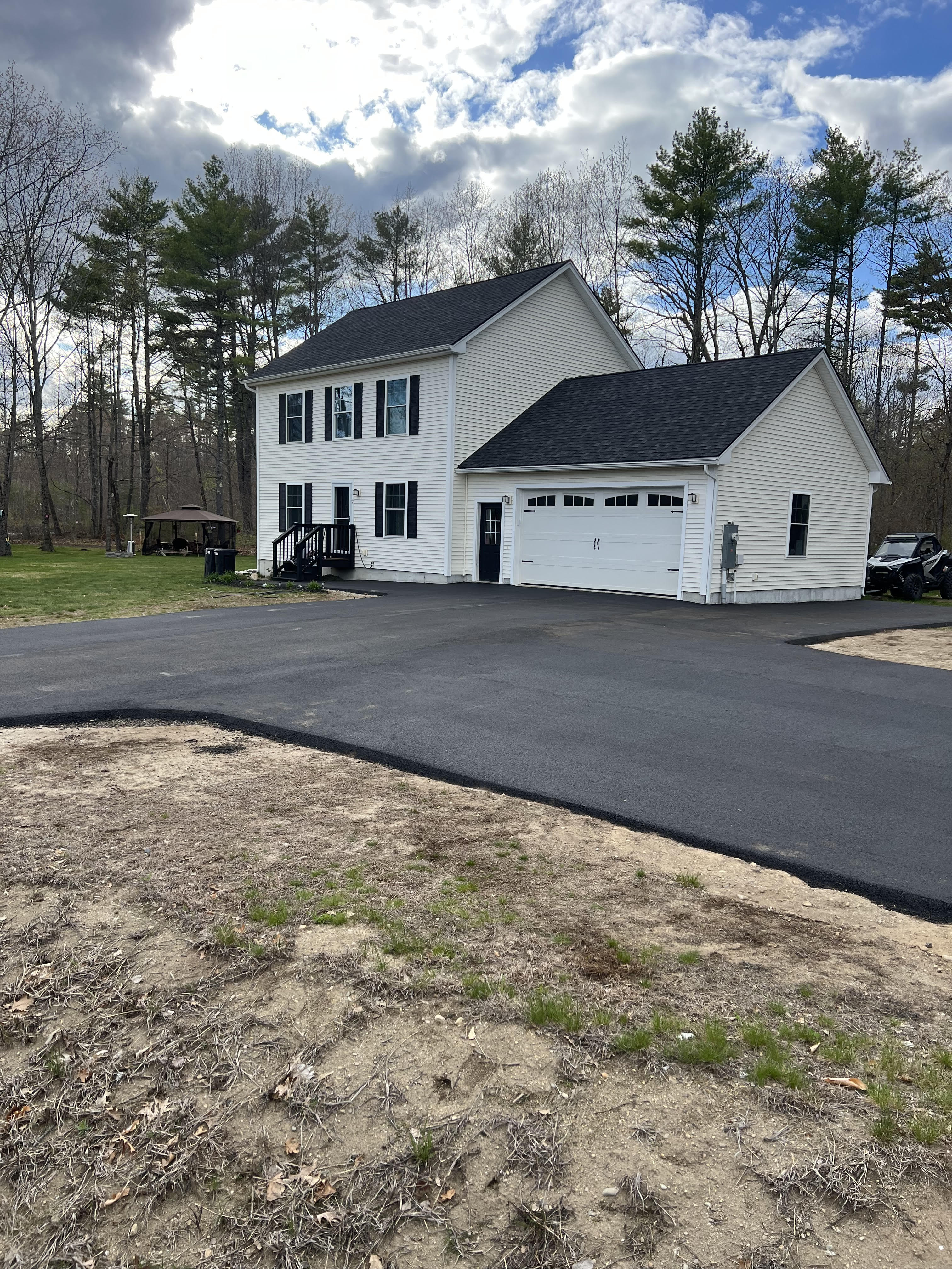 A large, freshly sealcoated commercial parking lot with crisp yellow line striping