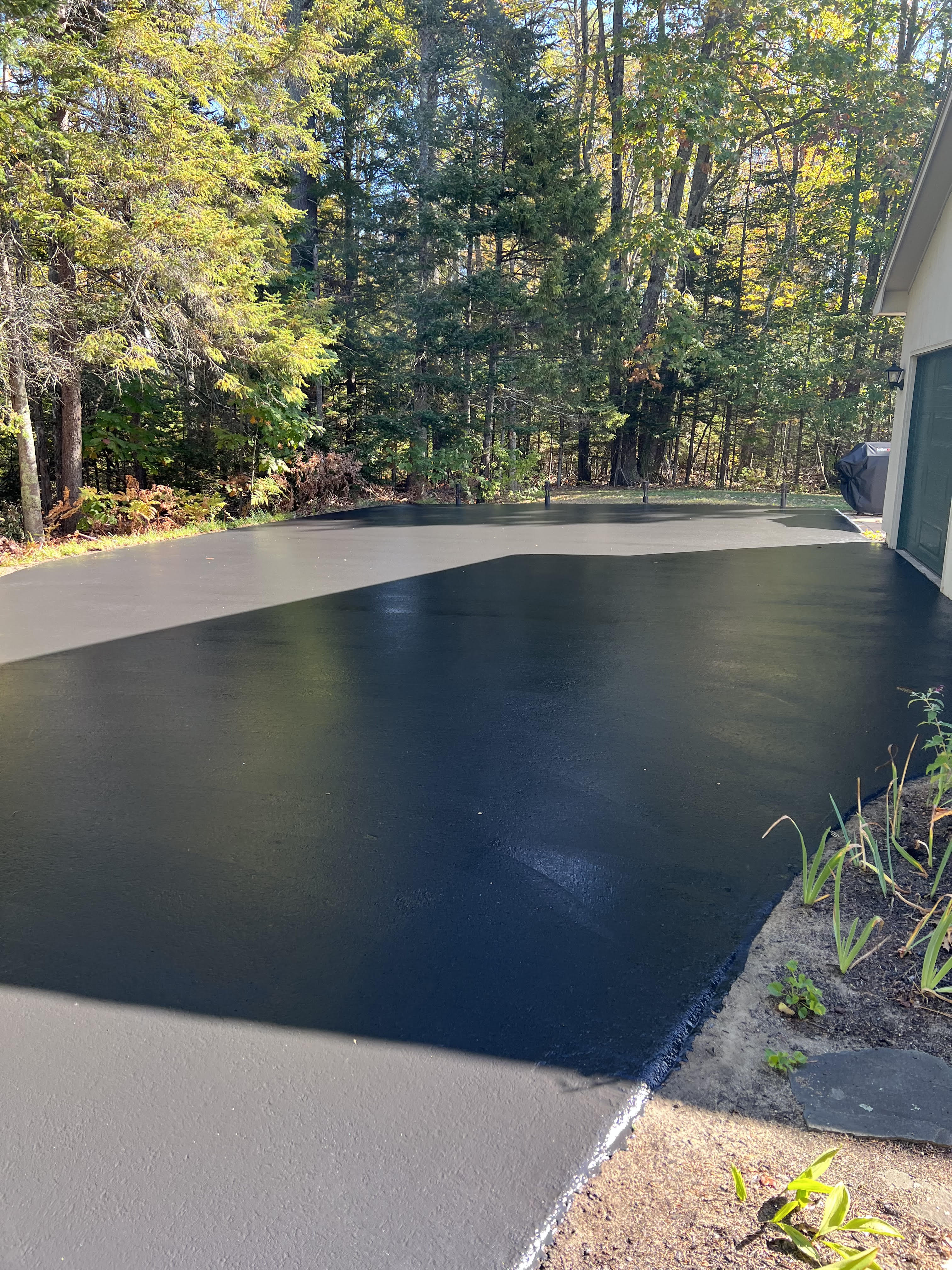 Before and after comparison of cracked asphalt restored to smooth new pavement