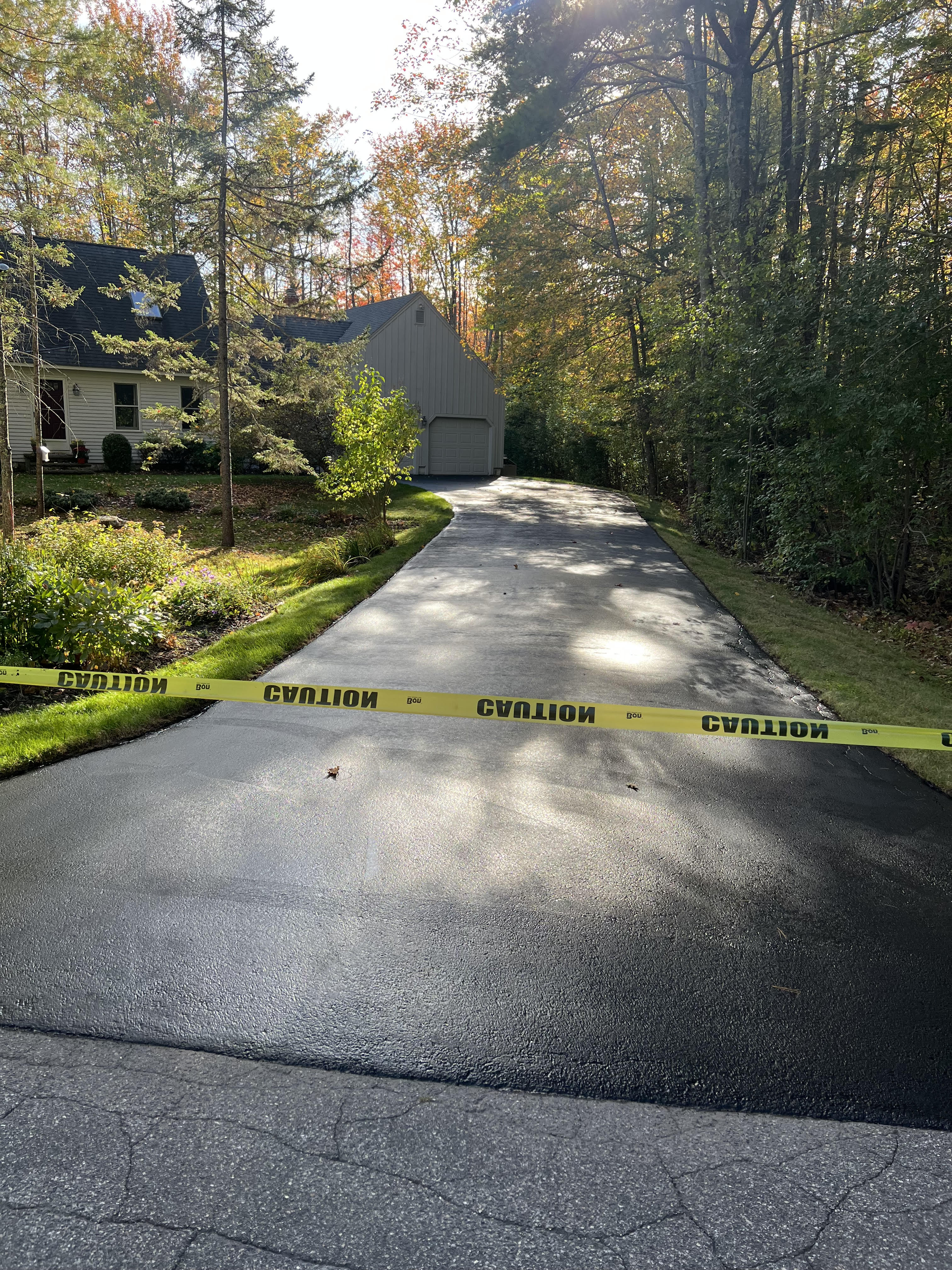 Long winding private asphalt road through wooded Maine property