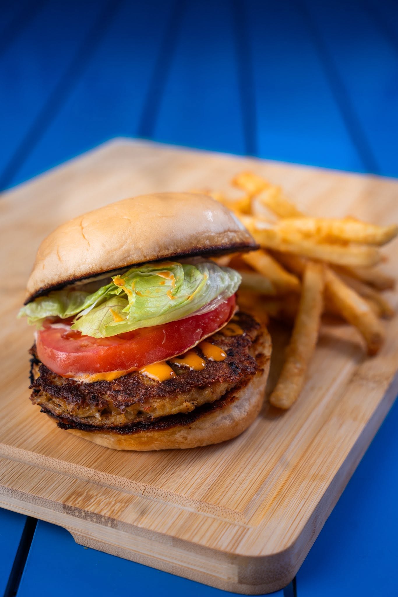 Juicy gourmet seafood burger on a brioche bun with fries