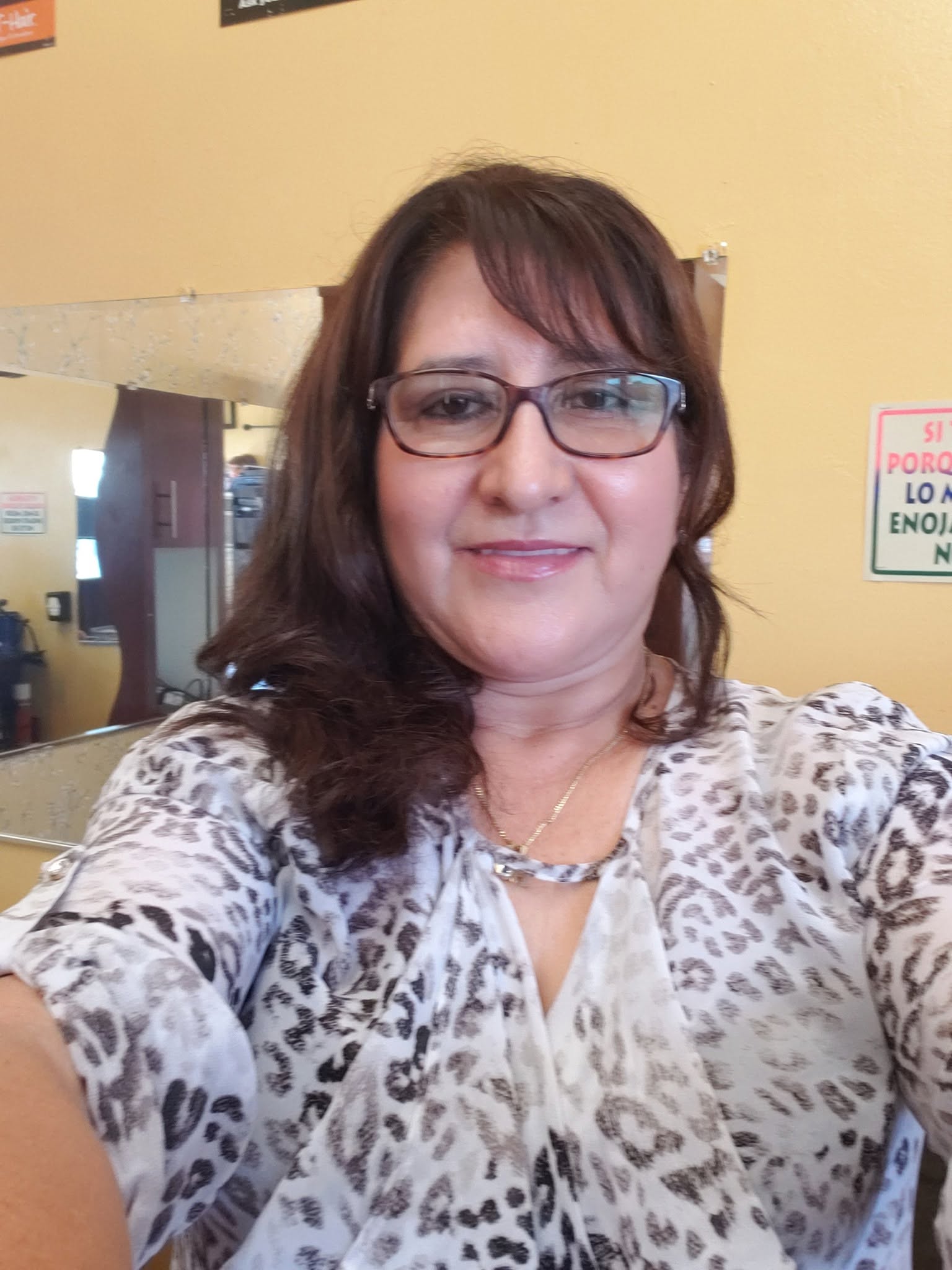 Aurelia Velasco, owner and stylist of Vel's Salon, smiling warmly in her beautifully lit salon
