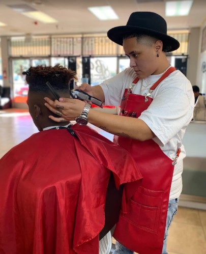 Master Barber Dre providing a precision fade haircut to a client in his modern barbershop
