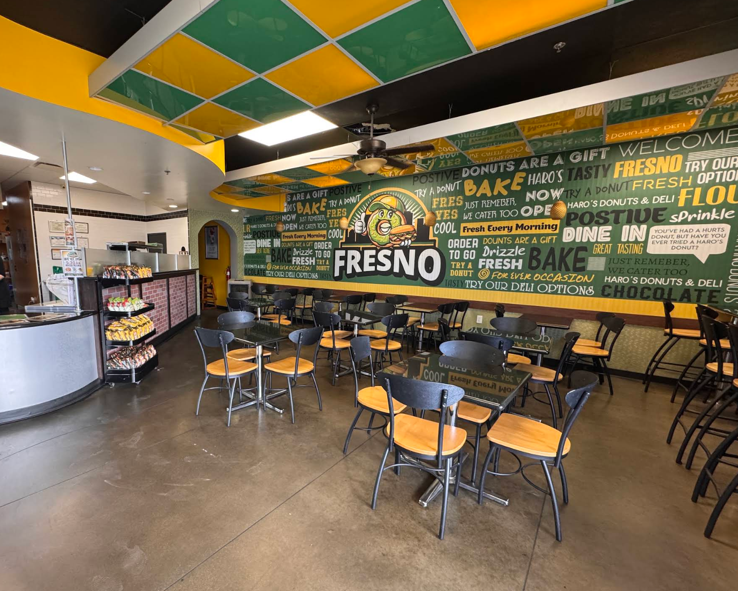 Cozy interior of Haro's Donuts & Deli with warm wooden counter and glass display case full of freshly glazed donuts