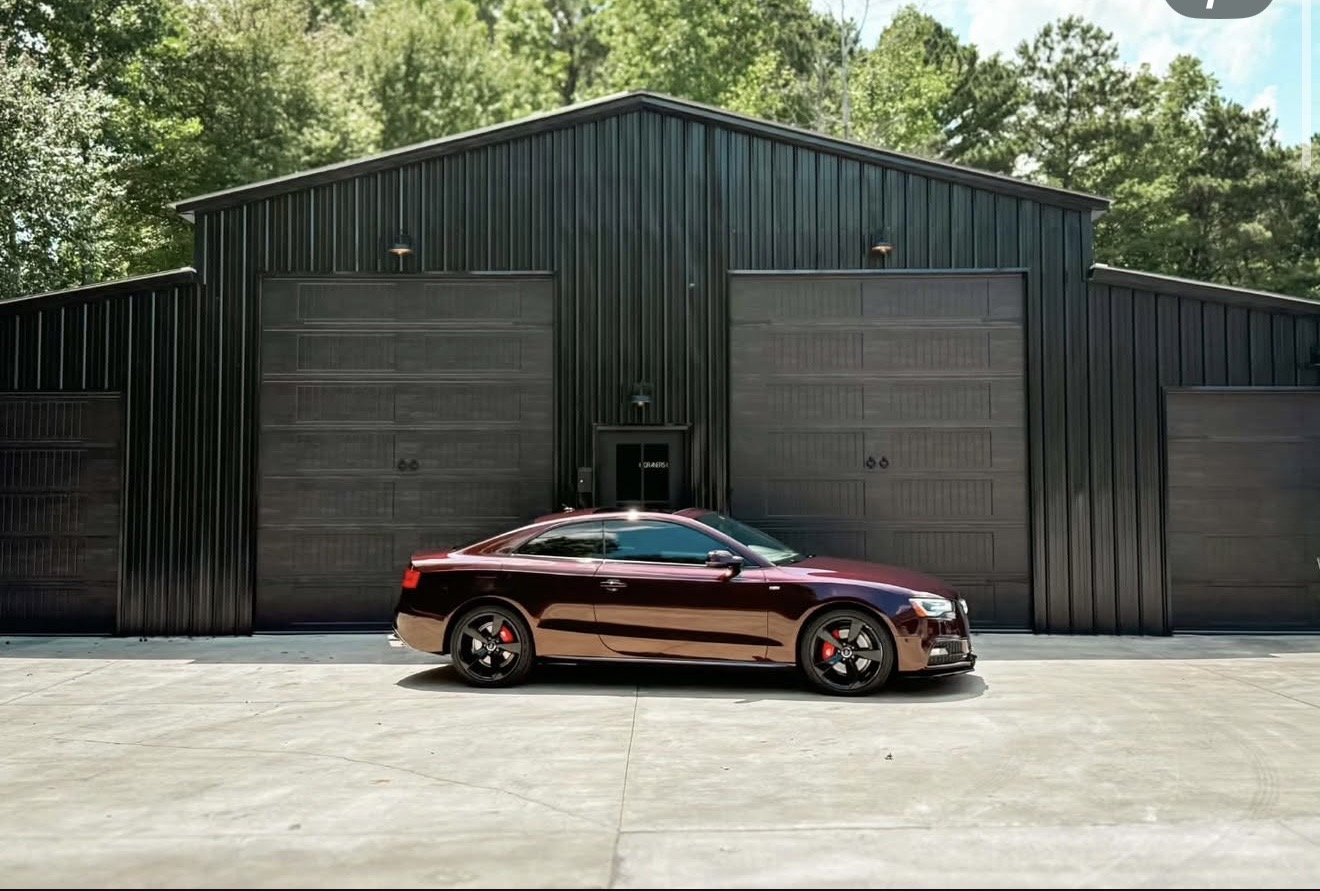 Meticulous auto detailer applying ceramic coating with precision under focused lighting