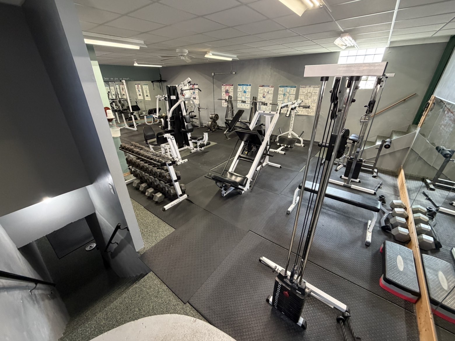 Real gym equipment, heavy free weights and squat racks in a local neighborhood gym