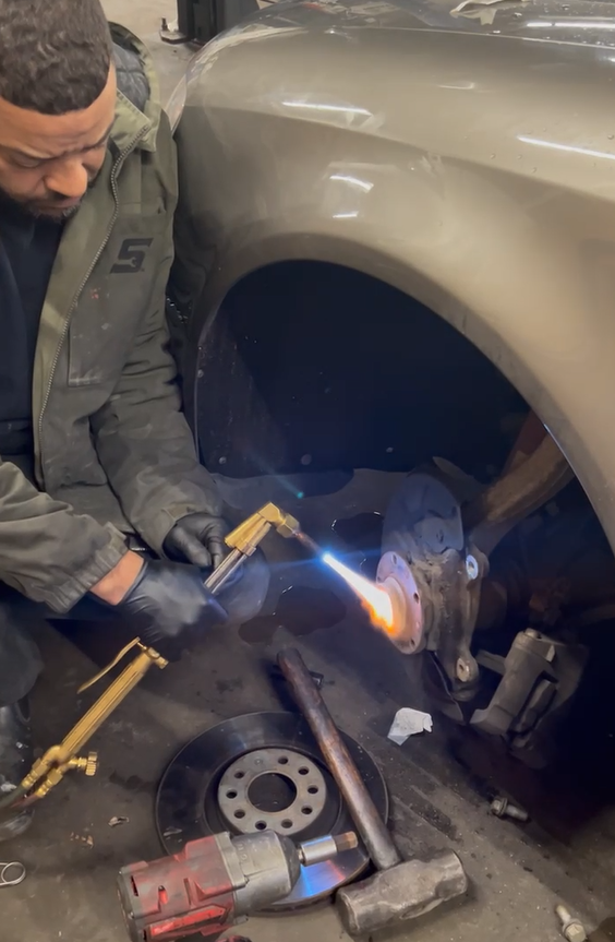 Certified technician replacing brake pads and rotors on a customer vehicle