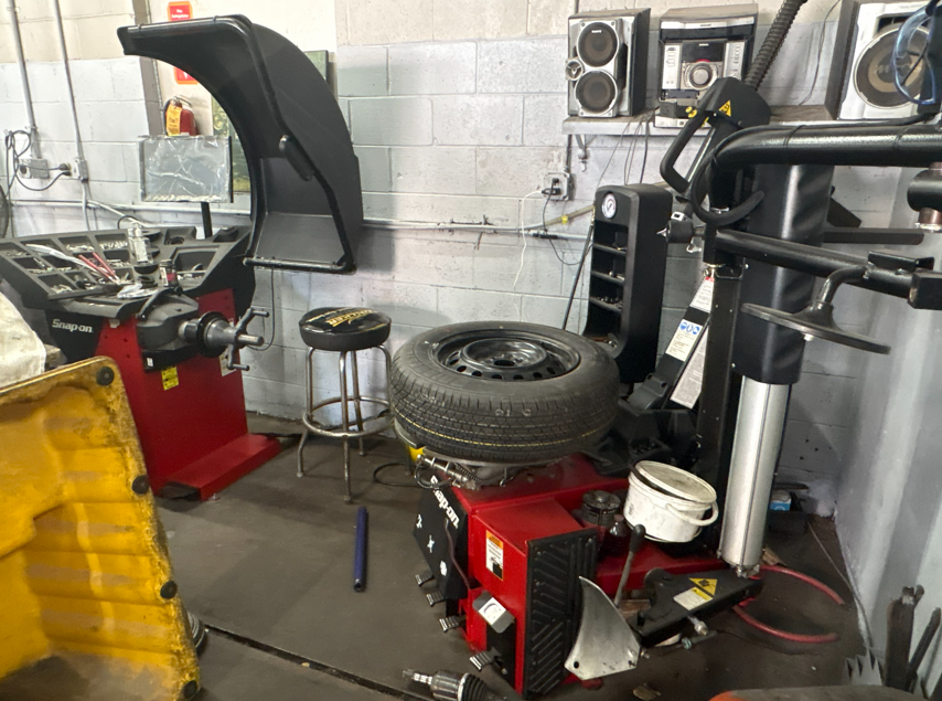 Tire rotation and wheel alignment service being performed on a customer vehicle