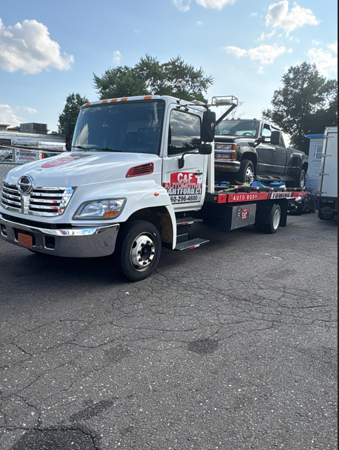 C&F Automotive tow truck assisting a stranded driver on a Hartford road at night