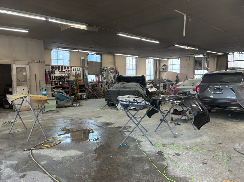 Body shop technician repairing damaged vehicle panel in Hartford