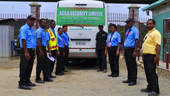 Uniformed static security guard standing at building entrance