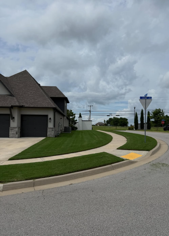 Close up of a professional lawn mower cutting vibrant fresh green grass on an Oklahoma residential property