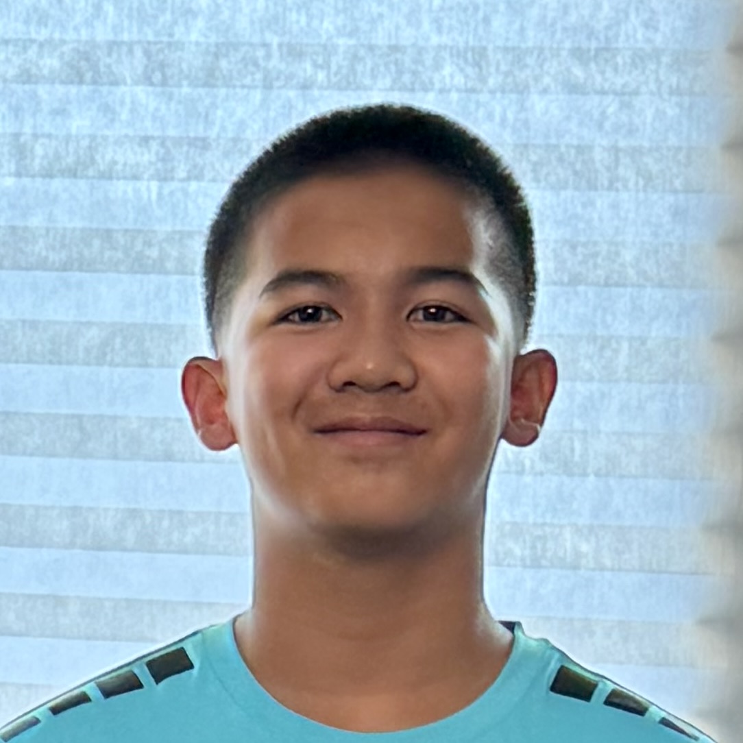 Young, focused web developer Jaden Herrera at his coding setup