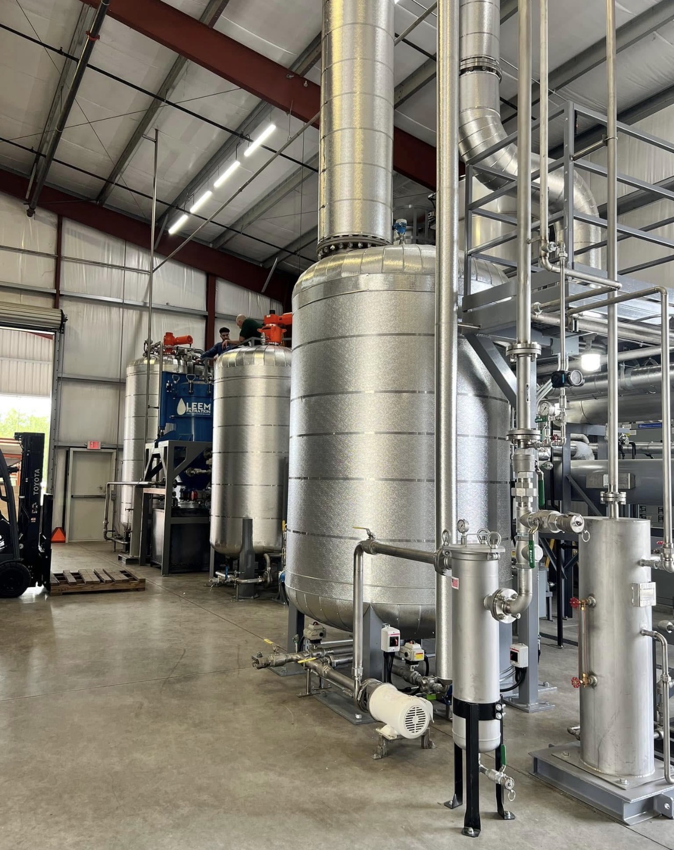 Large industrial gate valve fitted with a custom removable insulation jacket featuring stainless steel buckle straps for easy maintenance access.