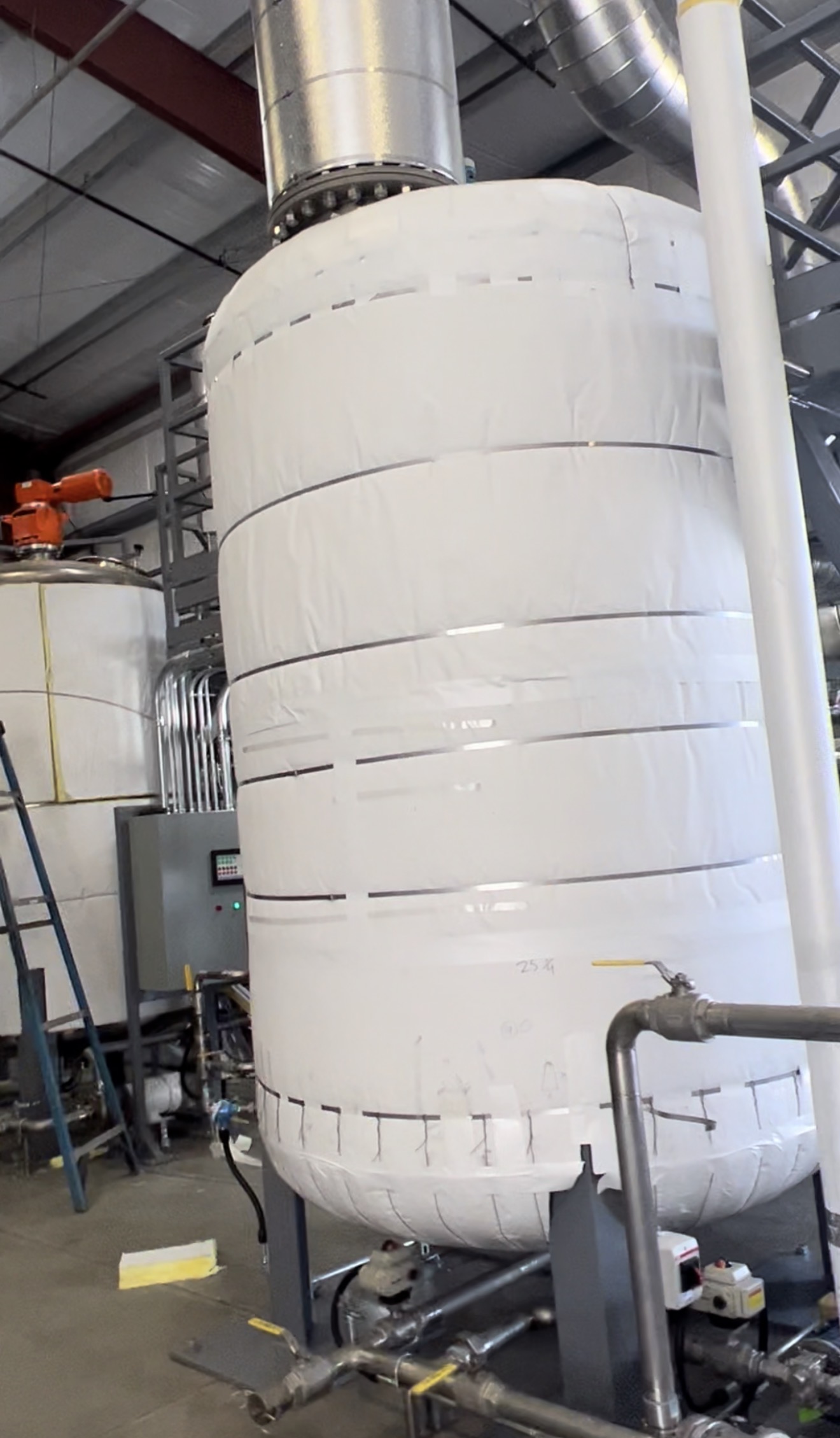Insulated chiller piping system in a commercial mechanical room with seamless vapor barrier jacketing and precision-fitted fiberglass insulation to prevent condensation.