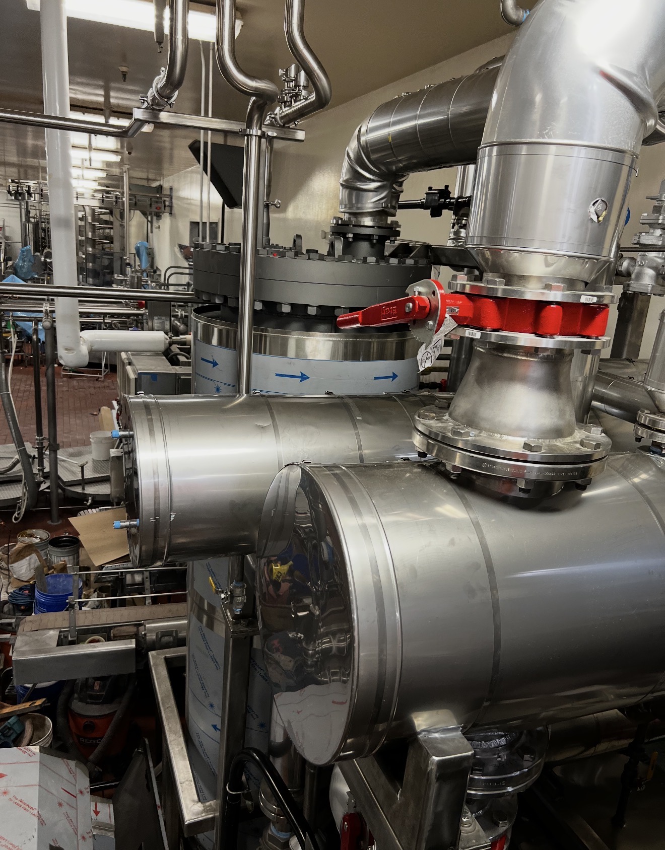 Sanitary food-grade process piping in a food processing plant insulated with FDA-compliant materials and finished with smooth stainless steel jacketing for hygiene and easy washdown.