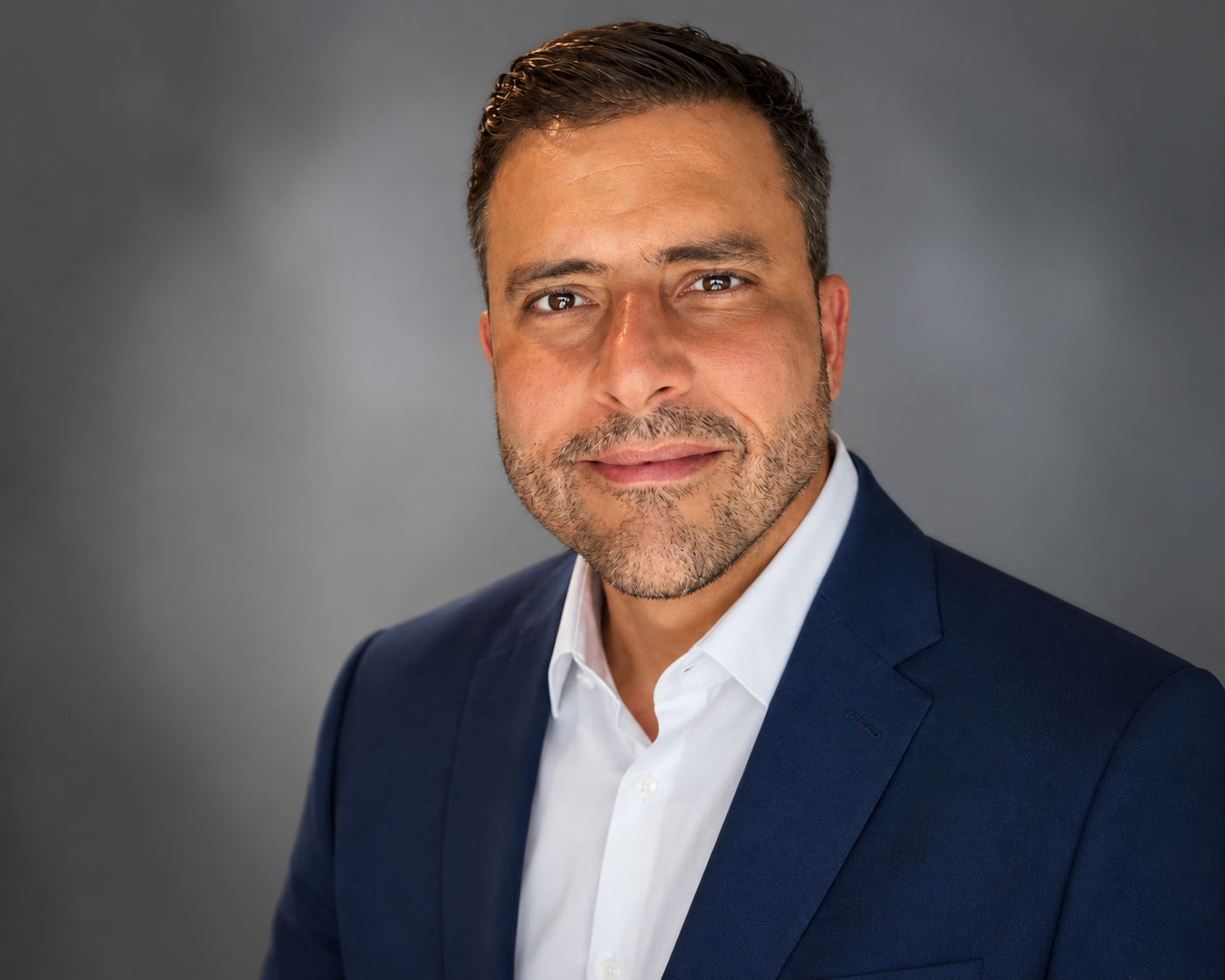Professional portrait of Rey Rodriguez, U.S. Army veteran, and founder of Valor Web Studio in business attire