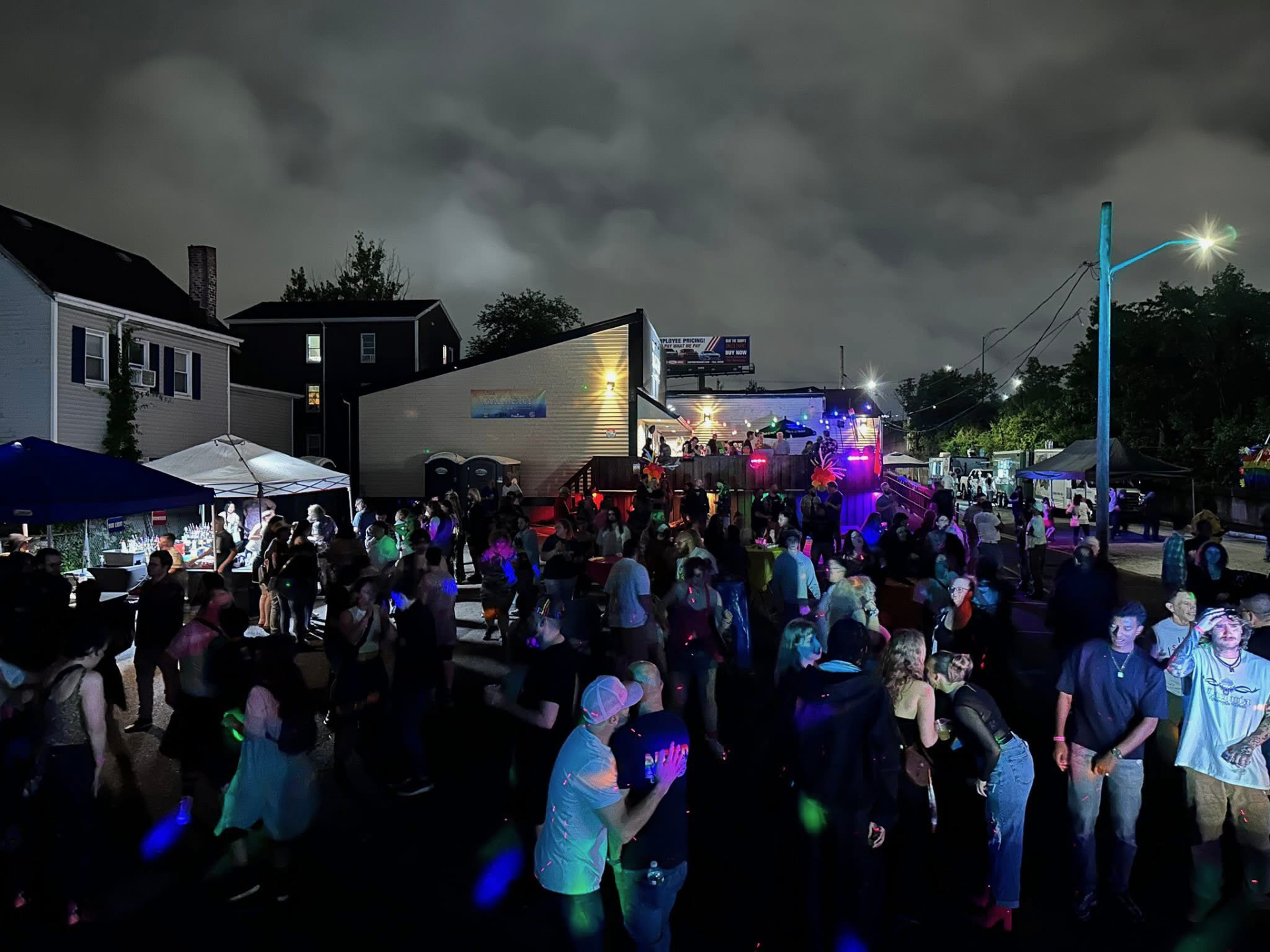 Energetic dance floor with DJ booth and vibrant pink neon lights illuminating the crowd
