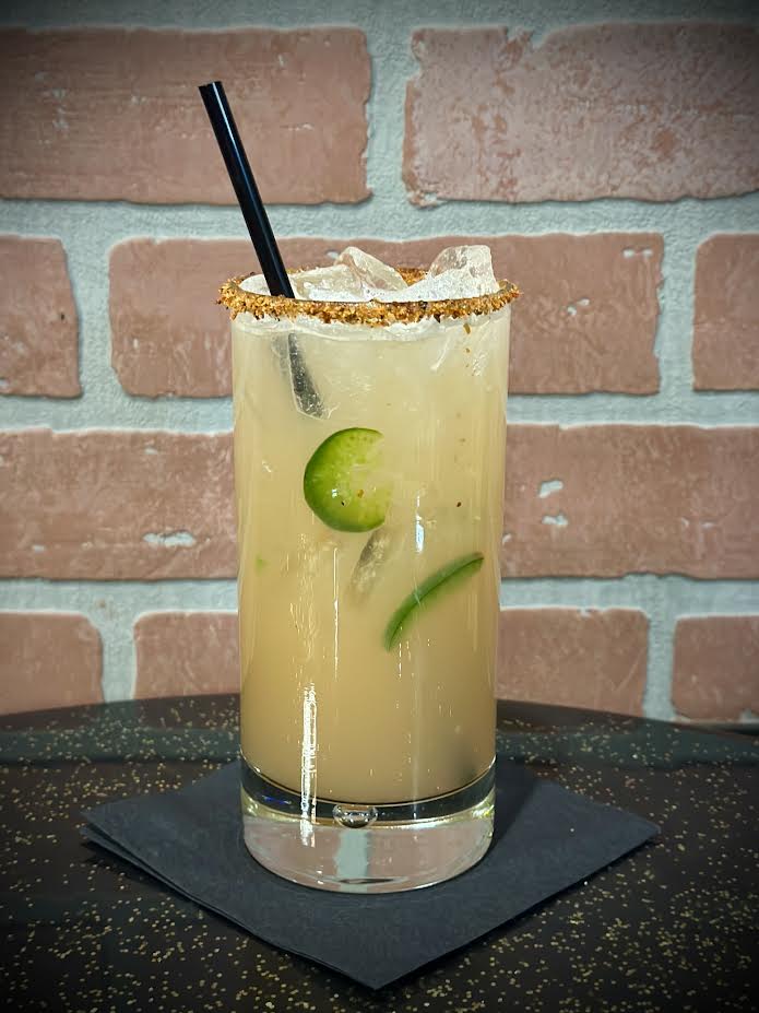 Elegant signature craft cocktail with smoke garnish in moody speakeasy lighting
