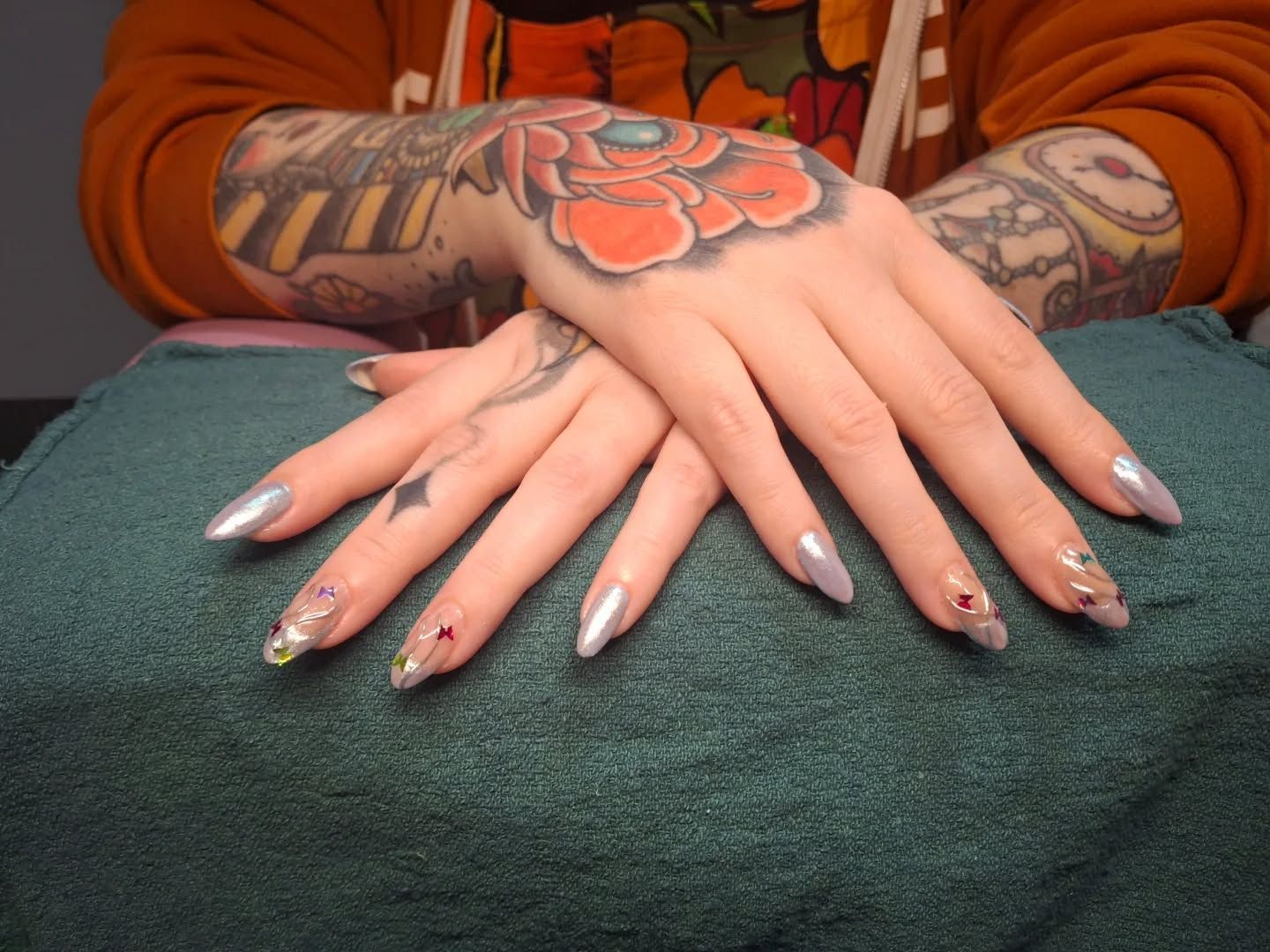 Dramatic stiletto-shaped nails with dripping silver chrome finish and mirror-like reflection crafted by Carissa.