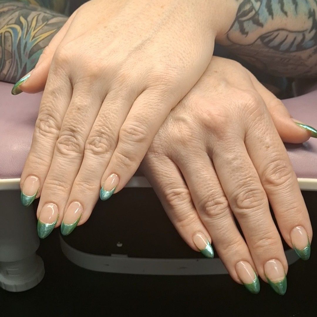 Luxurious deep emerald green almond nails adorned with hand-placed crystal embellishments by Carissa.