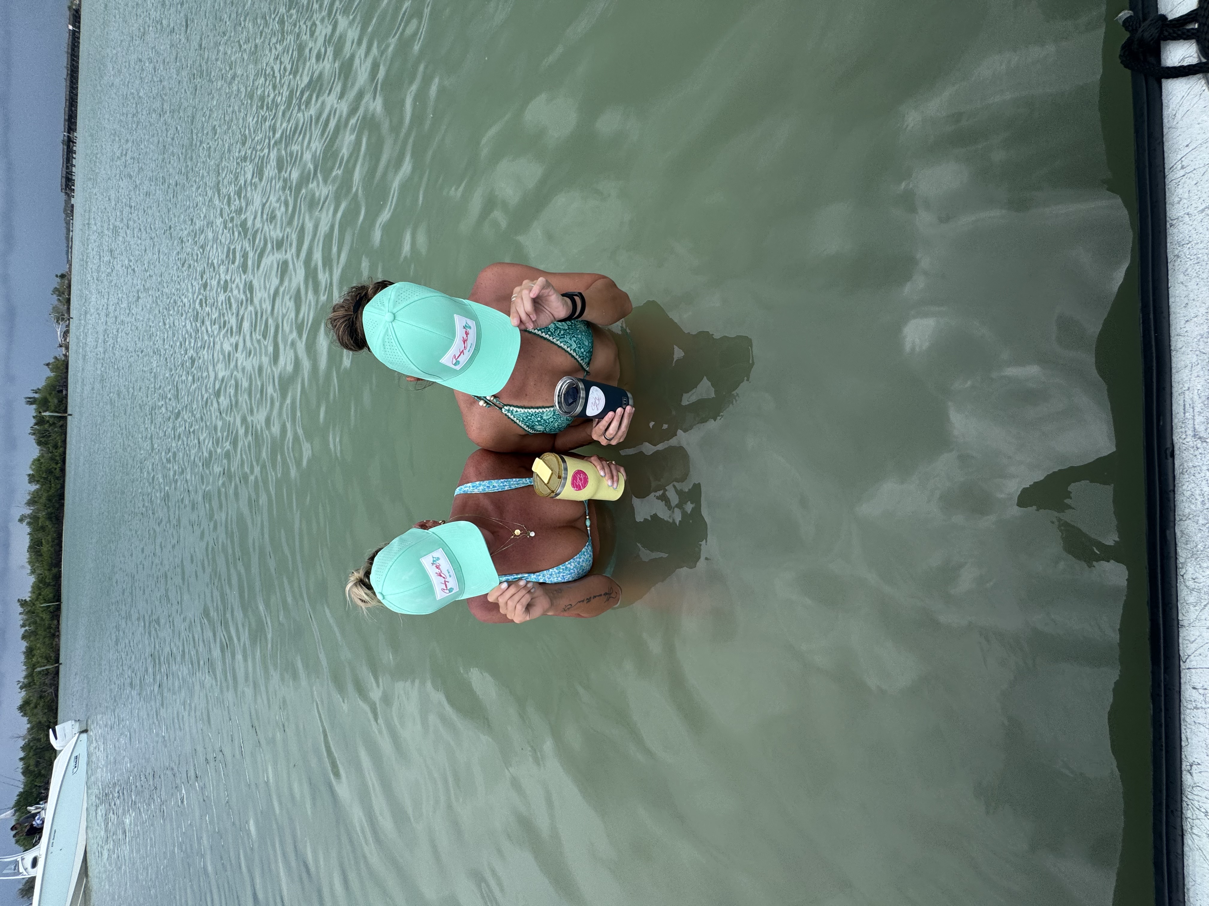 Women enjoying a sunny beach day in Cheeky Buttz swimwear